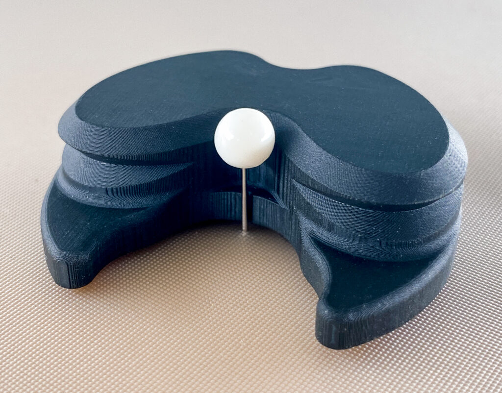 Close-up of the round foot, resting against a pushpin that marks the centre of the polygon.